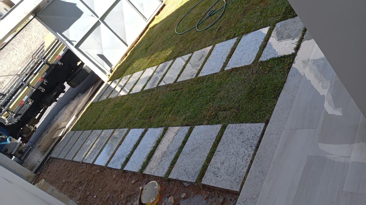 Pisadas de ardósia aplicadas sobre grama em obra