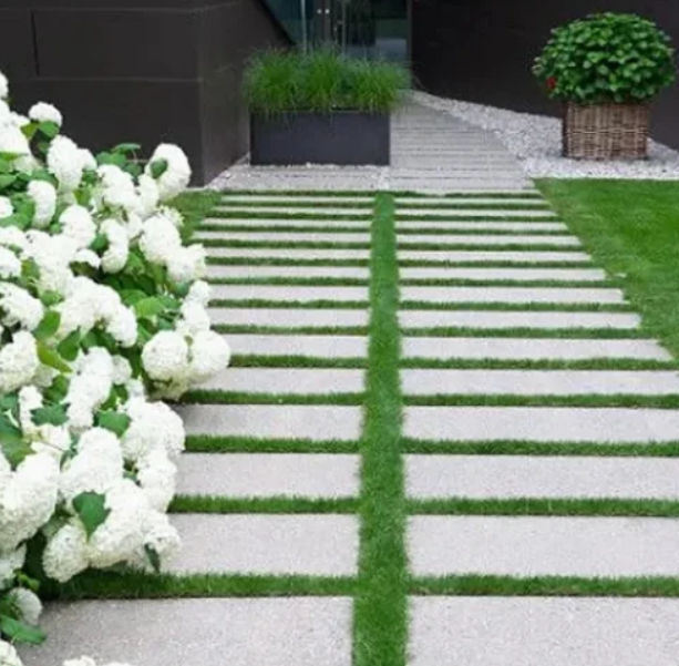 Caminho de jardim com pisadas de ardósia cinza natural 100x30cm entre faixas de grama
