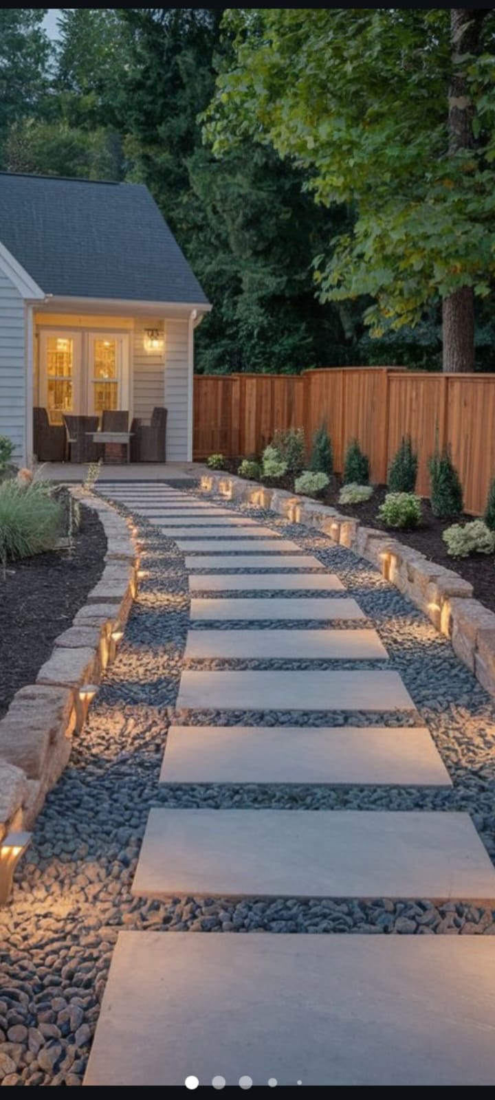 Caminho de pisadas de ardósia iluminado em jardim residencial